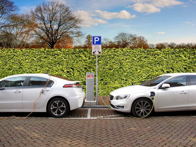 Samochody elektryczne stoją na parkingu podczas ładowania silnika
